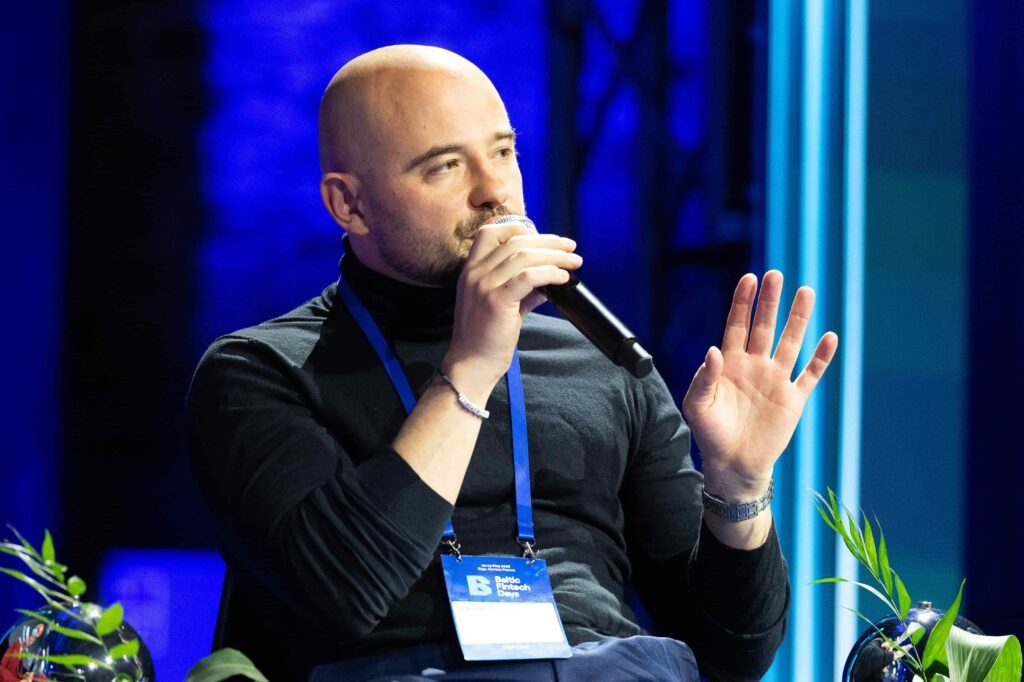 Speaker presenting on stage at a fintech industry conference